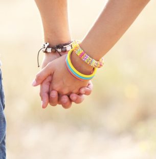 happy-couple-holding-hands-outdoors_392895-318618